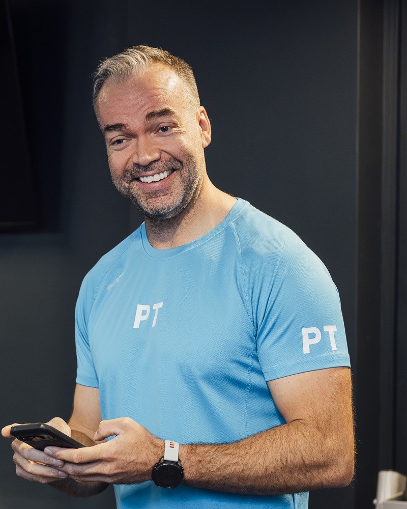 Personlig trener med treningsprogrammet på mobilen
